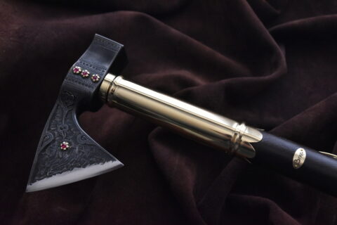 Jánošíkova valaška oceľová, zdobenie: hĺbkový reliéf, syntetické rubíny, mosadzné zdobenia, kožená rúčka, farba: čierna + Kožené puzdro na čepeľ